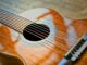 Detailed view of a classical acoustic guitar focusing on strings and soundhole.